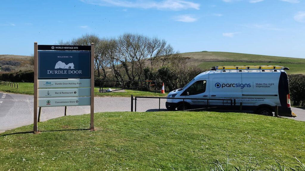 Durdle Door World Heritage Site welcome signage with Parc Signs van next to it