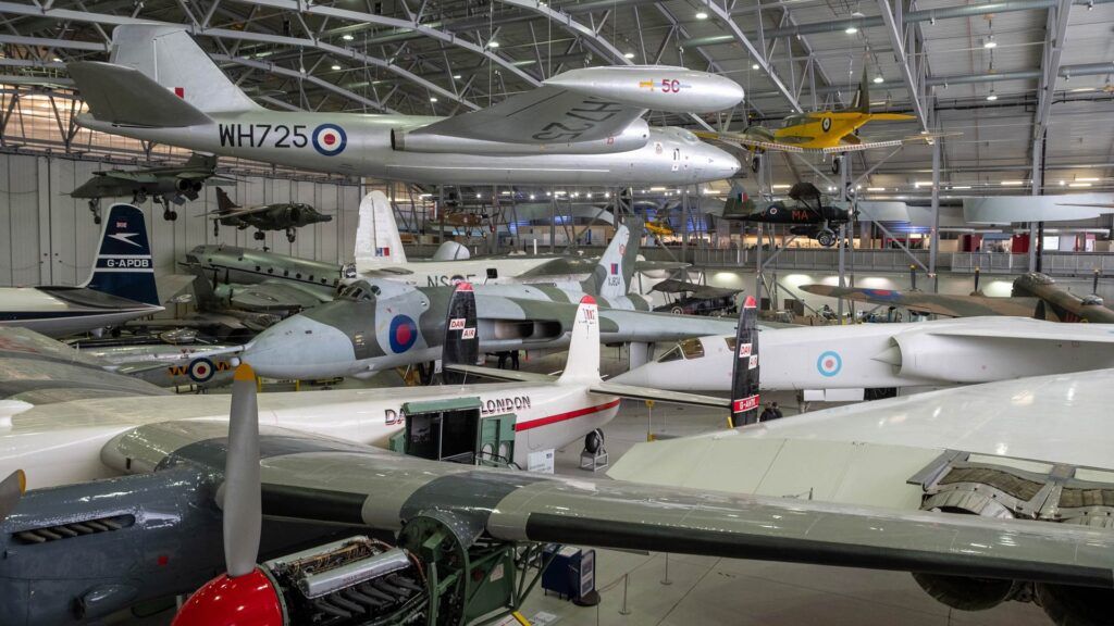 Imperial War Museum, Duxford: hangar containing military aeroplanes parked ont he ground and suspended from ceiling