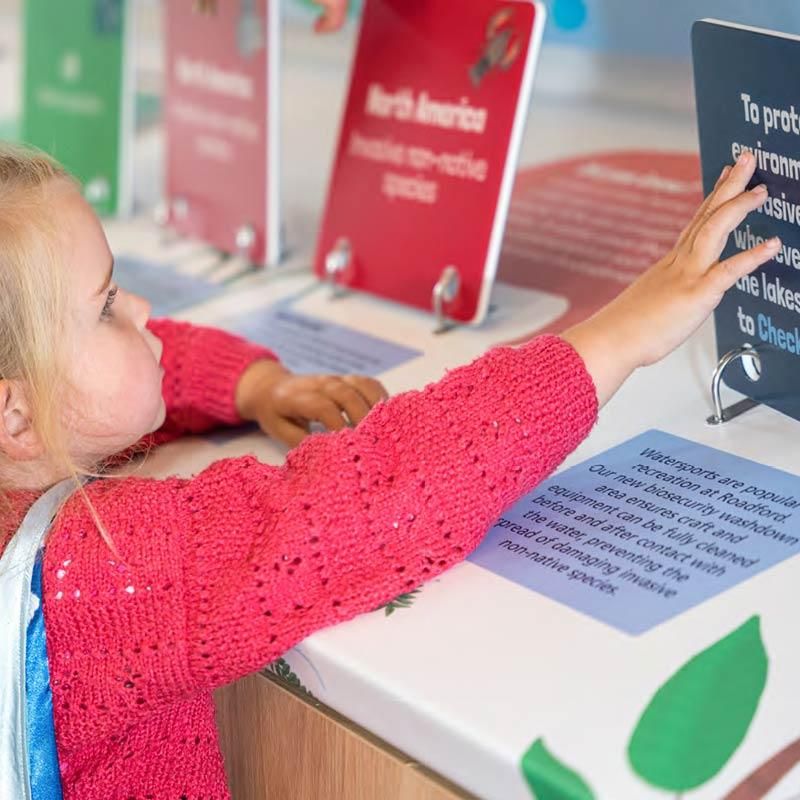 Young girl reading interactive water exhibition