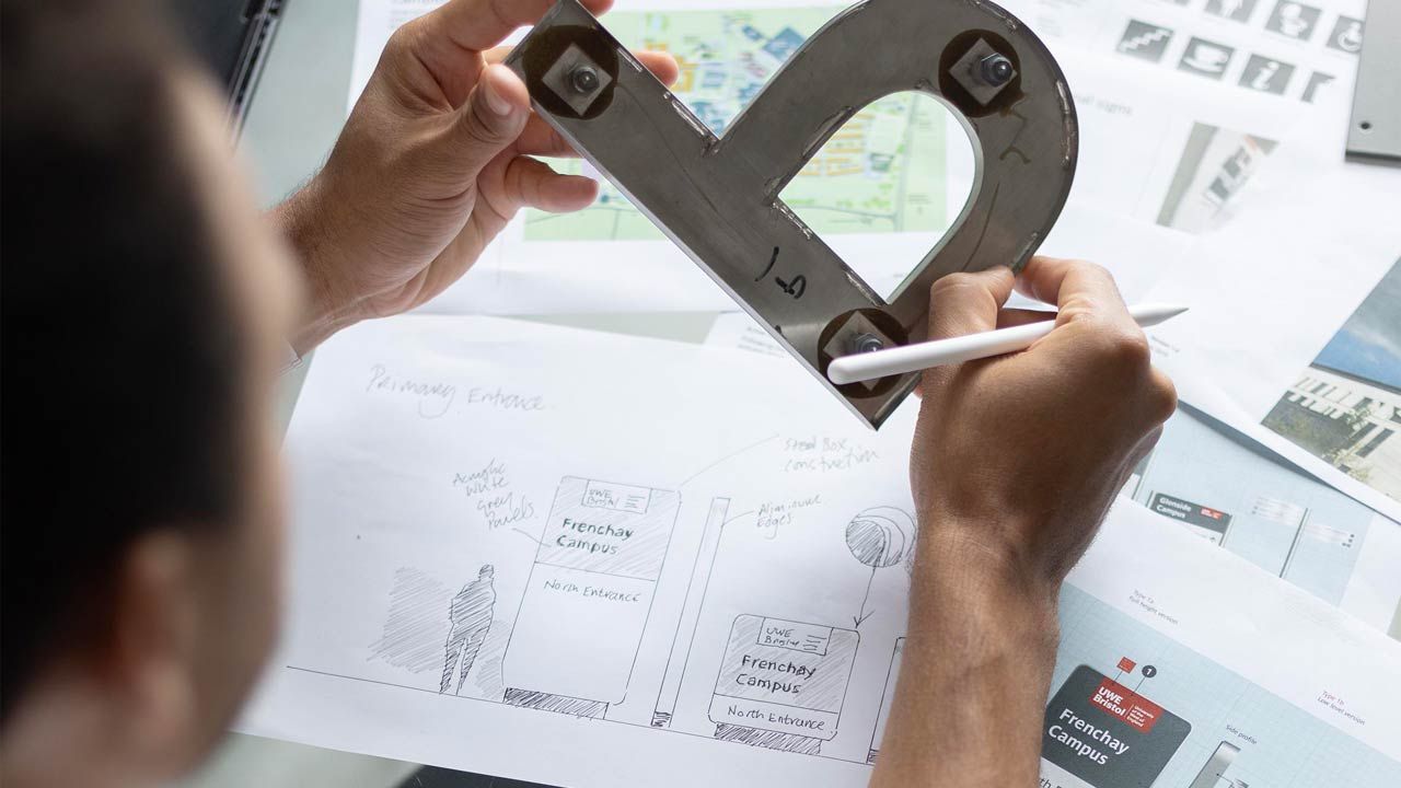 Jacob at desk designing Frenchay Campus wayfinding